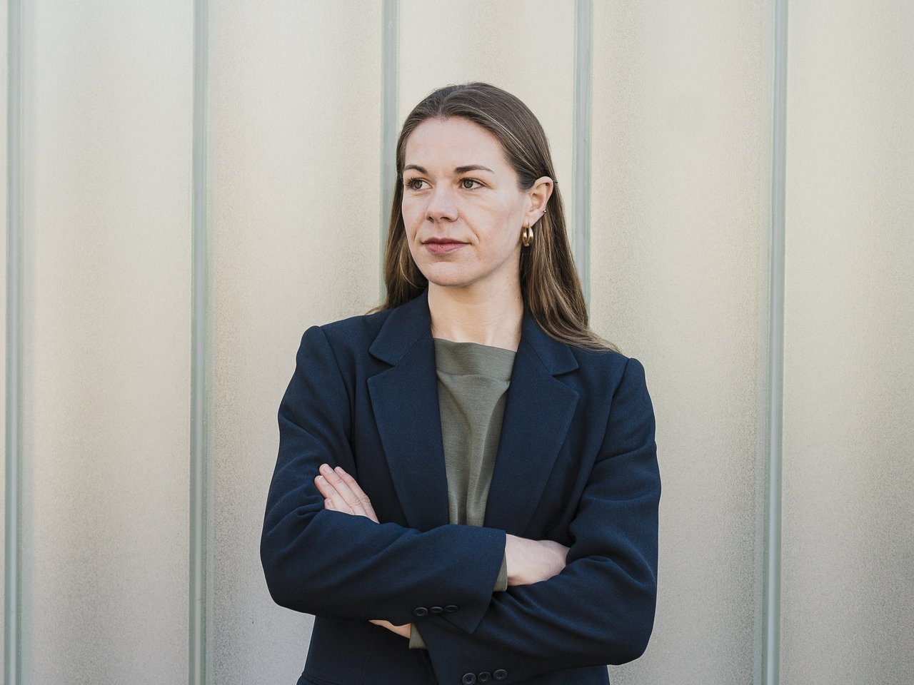 Sarah Heim steht mit verschränkten Armen vor einer Glasfassade in Waiblingen